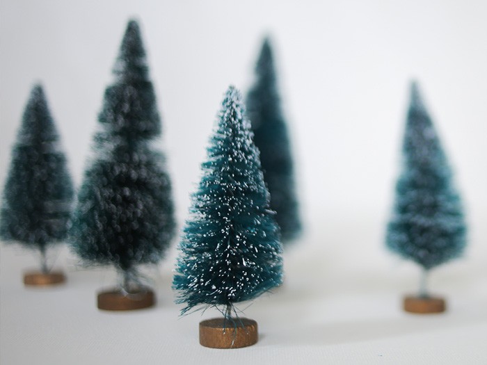 Collection de faux pins miniatures aux branches enneigées. 